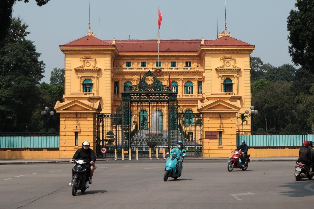 People ride motorbikes past the Presidential Palace in Hanoi. Photo: EPA-EFE