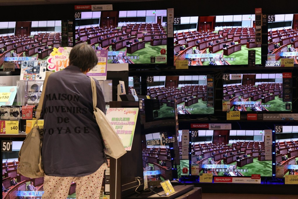 A shopper watches proceedings on television as Hong Kong lawmakers scrutinise the new domestic security bill. Photo: Jelly Tse