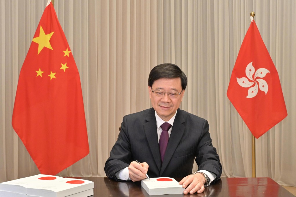 ​Hong Kong Chief Executive John Lee signs the Safeguarding National Security Ordinance into law on Friday. Photo: Handout