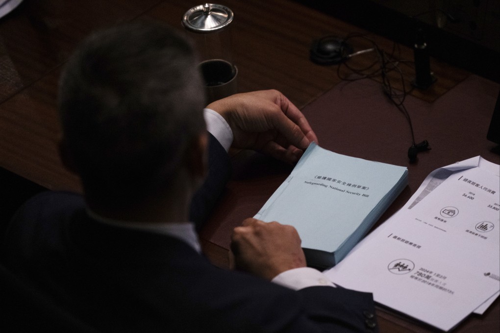 A Hong Kong lawmaker holds a copy of the Safeguarding National Security bill in the city’s legislature on Tuesday. It passed unanimously on Wednesday. Photo: AP
