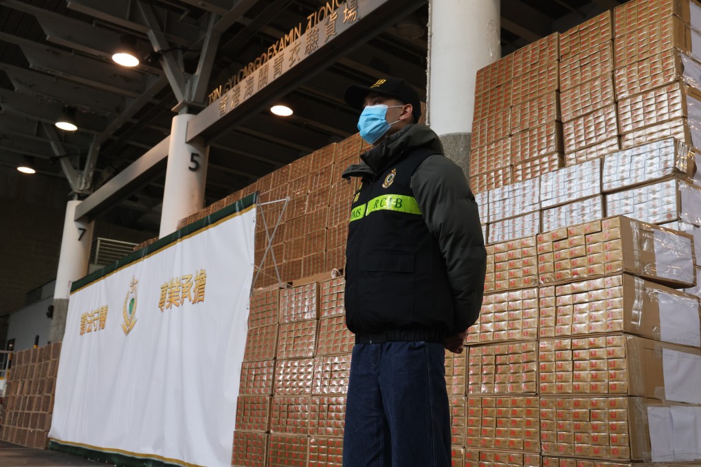 A customs officer stands guard over some of the millions of dollars worth of contraband cigarettes seized as part of the post-budget crackdown on contraband tobacco. Photo: Dickson Lee