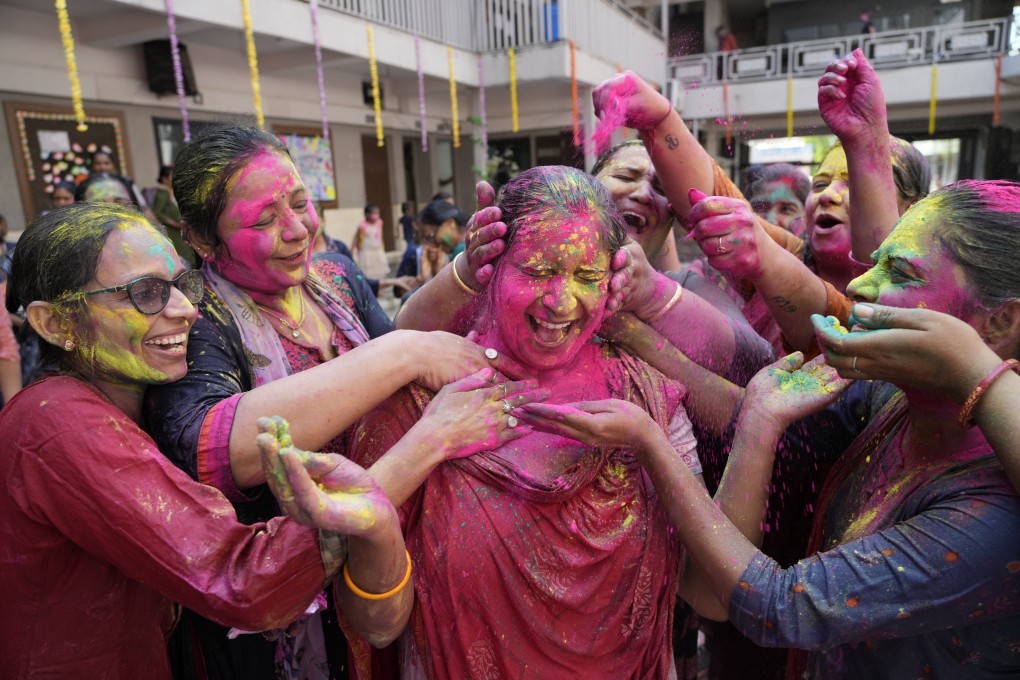 Teachers apply coloured powder on another as they celebrate Holi, the Hindu festival of colours, at a school in Ahmedabad, India. The festival has two origin stories that are rooted in mythology. Photo: AP