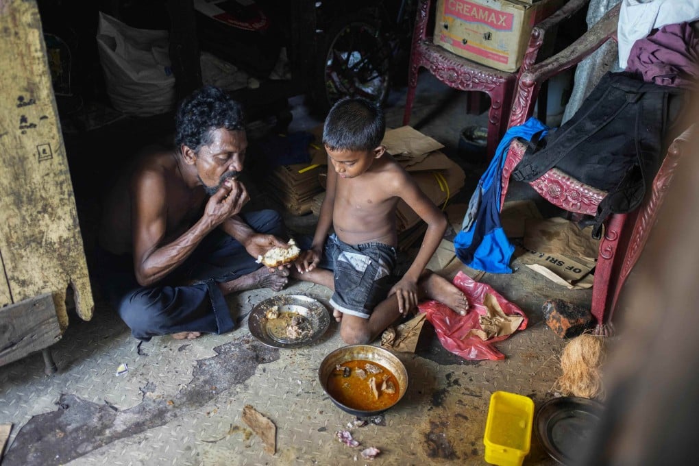 A father and son share a meal at their shanty in Colombo, Sri Lanka, on October 5, 2022. Photo: AP