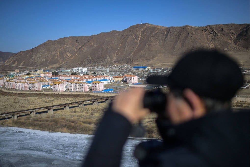 A man uses a pair of binoculars to look towards the North Korean city of Namyang, from the city of Tumen in northeast China’s Jilin province. Photo: AFP