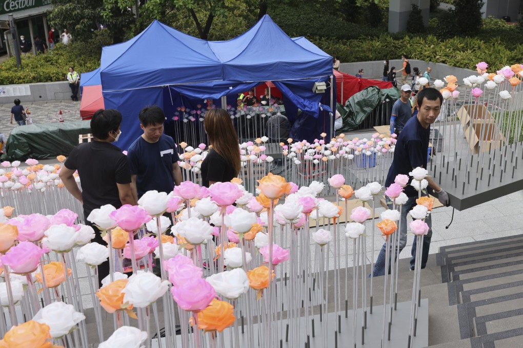 Workers set up an LED flower art installation outside the East Kowloon Cultural Centre in Kowloon Bay. Photo: Yik Yeung-man