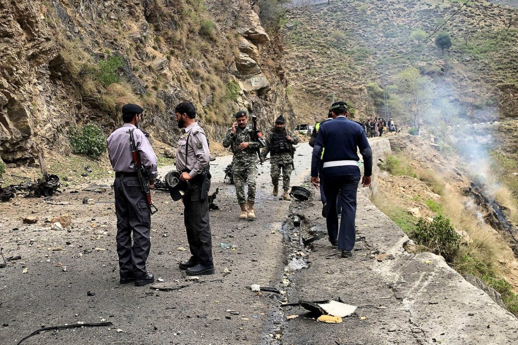 Security personnel inspect the site where a suicide bomber rammed a vehicle into a convoy of Chinese engineers working on a dam project in northwest Pakistan on Tuesday. Photo: AFP