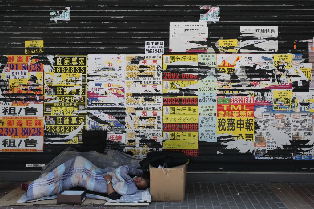 A homeless man sleeps in front of a shuttered shop in Mong Kok in April 2022. Photo: Edmond So