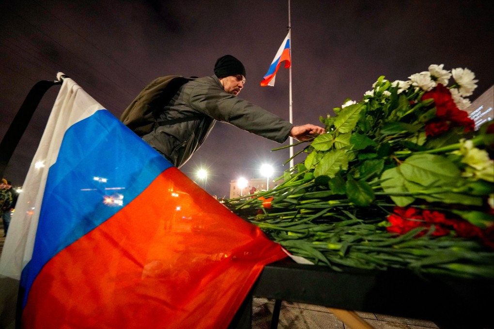 A man places flowers at a spontaneous memorial for the victims of the Moscow attack in St Petersburg, Russia, on March 23. Photo: AP