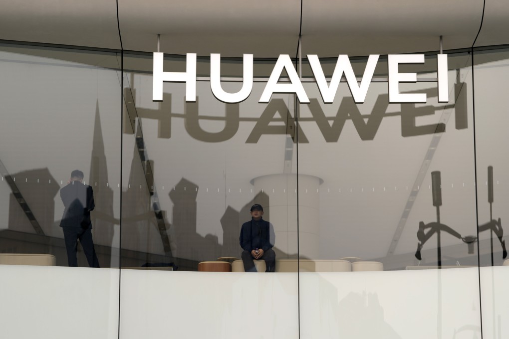 A visitor to the Huawei store in Beijing looks out the window near the logo for the Chinese telecoms equipment giant, March 26, 2024. Photo: AP