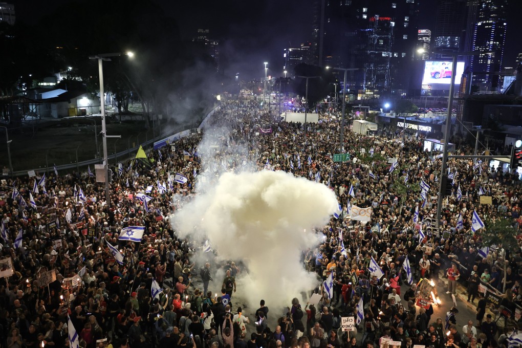 Smoke rises as family members and supporters of Israeli hostages held by Hamas in Gaza take part in a protest rally in Tel Aviv on March 30. Photo: EPA-EFE