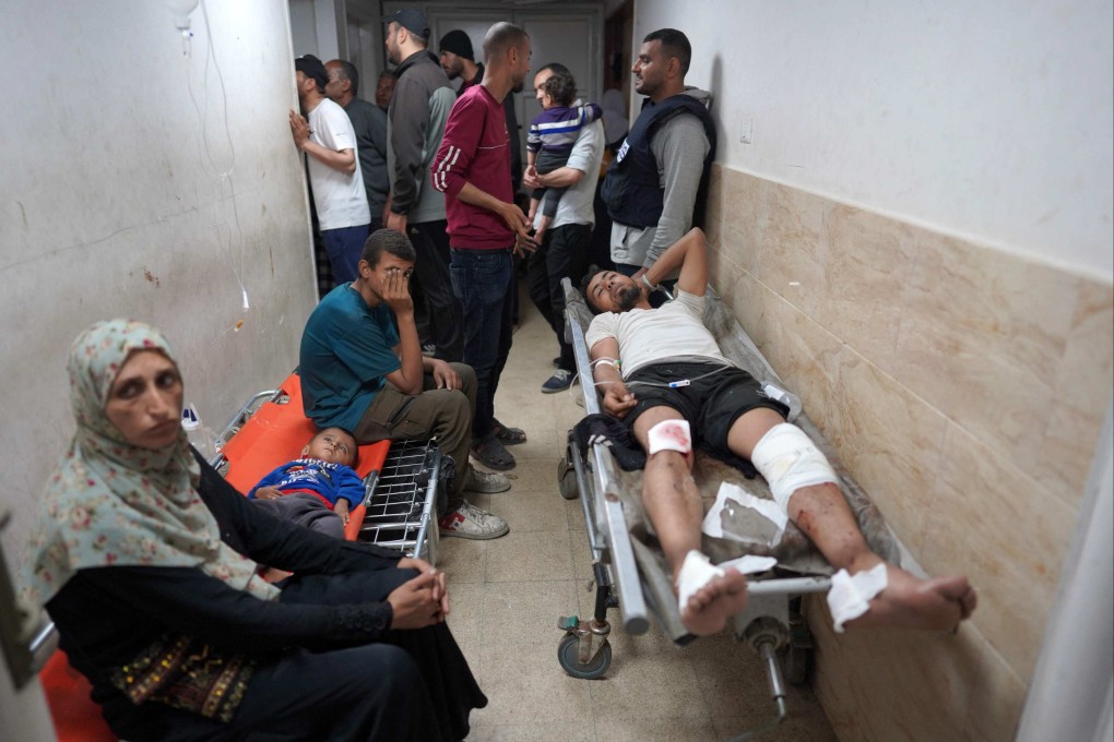 An injured Palestinian man lies on a stretcher in a corridor at the Al-Aqsa Martyrs Hospital. Photo: AFP