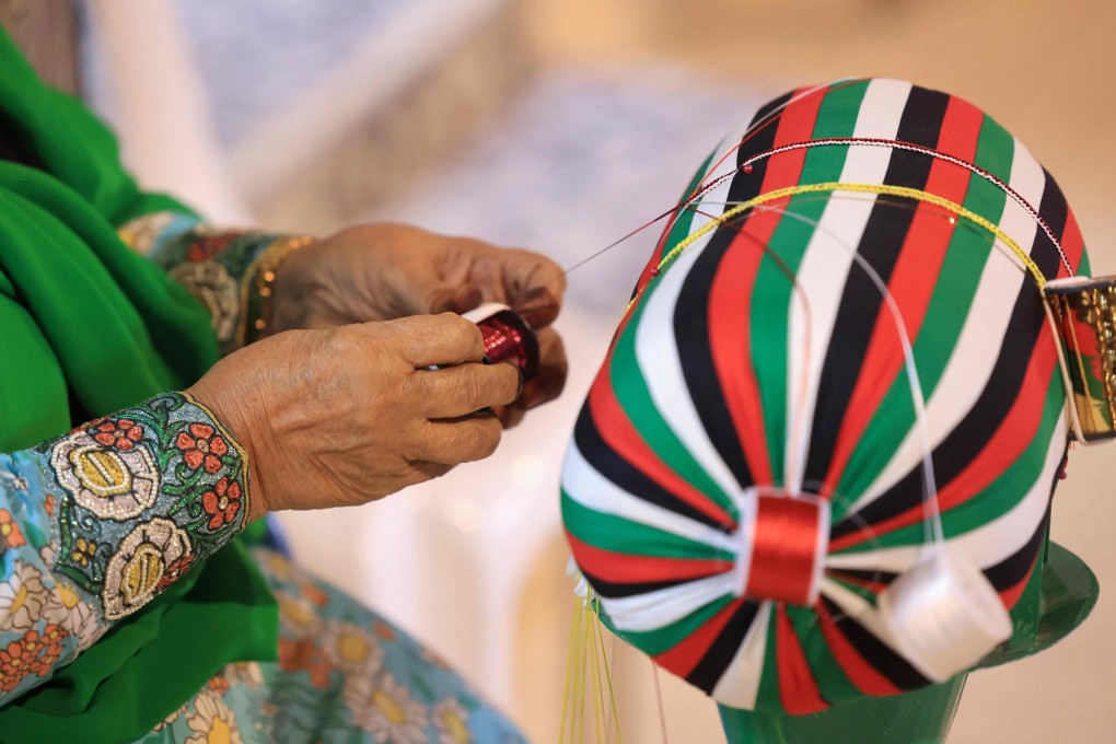An Emirati woman weaves thread in the Al Talli method during an annual heritage festival in Al-Ain. Al Talli, the art of hand-weaving braided shiny ribbons to adorn traditional clothing and bags, is on Unesco’s Intangible Cultural Heritage of Humanity list. Photo: AFP