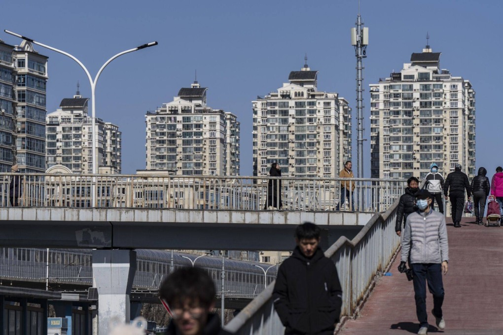 Pedestrians cross a footbridge near residential buildings in Beijing, on March 3, 2024. Photo: Bloomberg