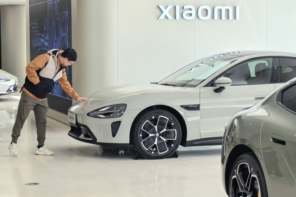 A consumer checks the hood of Xiaomi’s new electric vehicle, the SU7, at the company’s showroom in Beijing on March 30, 2024. Photo: Xinhua