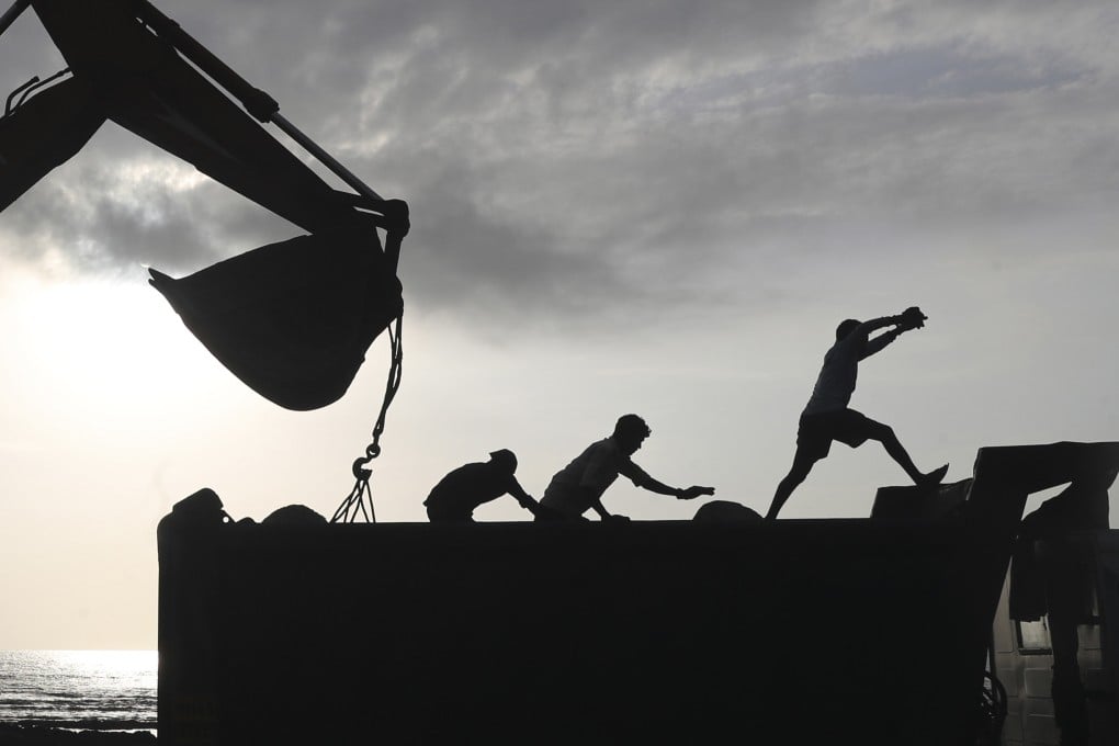 Workers use machinery at the construction site for a coastal road project in Mumbai, India. Photo: AP