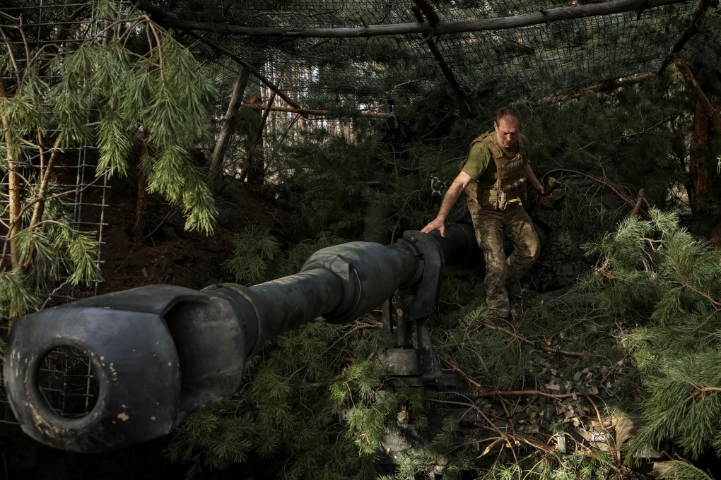 A Ukrainian serviceman camouflages a M109 self-propelled howitzer in Donetsk region, Ukraine, on Sunday. Photo: Reuters