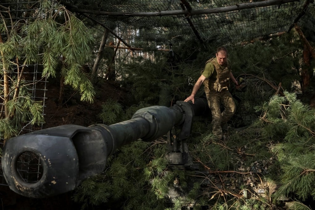 A Ukrainian serviceman camouflages a M109 self-propelled howitzer in Donetsk region, Ukraine, on Sunday. Photo: Reuters