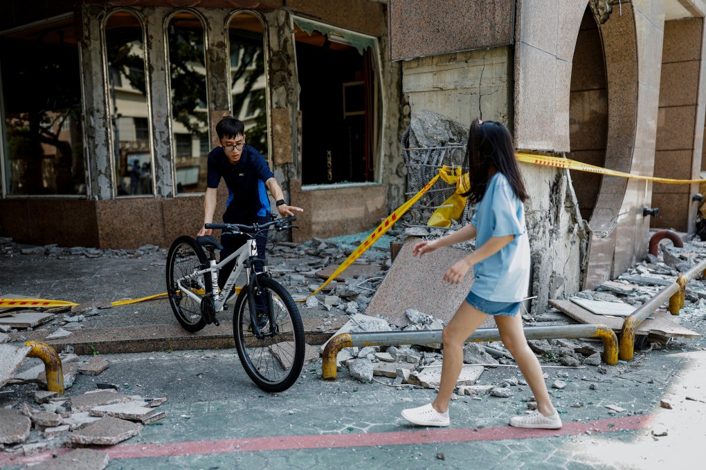 People move a bicycle from the rubble in Hualien. Photo: Reuters