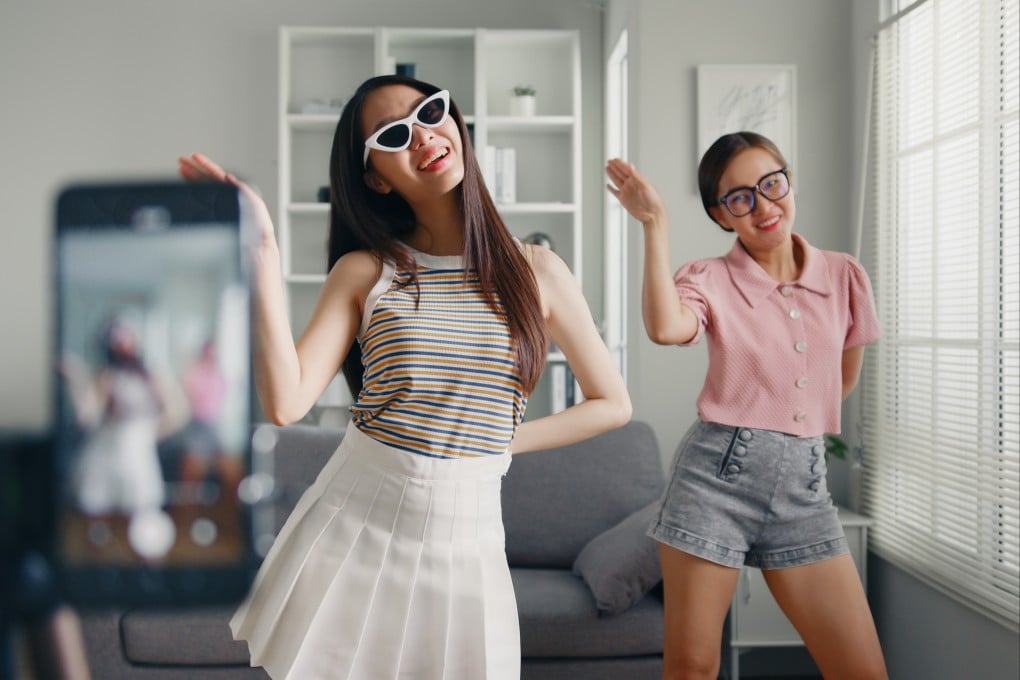 Teens film a TikTok dance video with a smartphone. TikTok challenges and trends are designed to feed an algorithmic popularity contest. Photo: Shutterstock