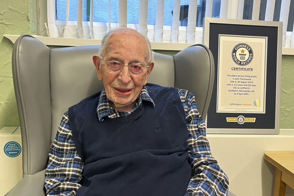 World’s oldest man John Tinniswood, 111, poses with his certificate from Guinness World Records in Southport, Britain, on Thursday. Photo: Guinness World Records via AP