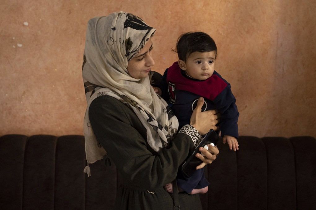 Amal Al-Taweel poses for a photo with her baby Ali in Nuseirat, central Gaza Strip on April 5. Photo: AP)