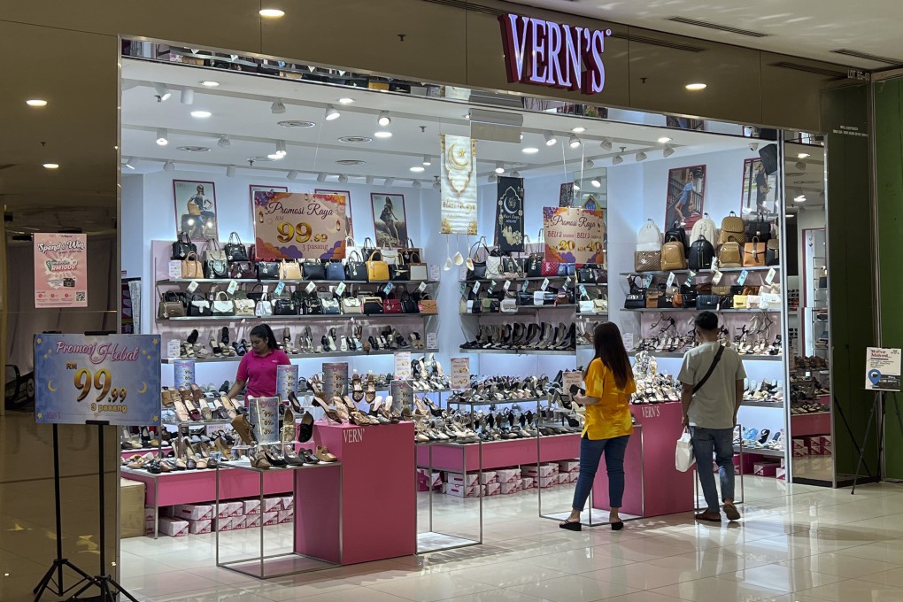 People shop at a Vern’s outlet at a shopping centre in Kuala Lumpur on Monday. Malaysian shoe company Vern’s Holdings apologised and stopped selling some of its footwear after some Muslims said the logo resembled the Arabic writing for the word God. Photo: AP