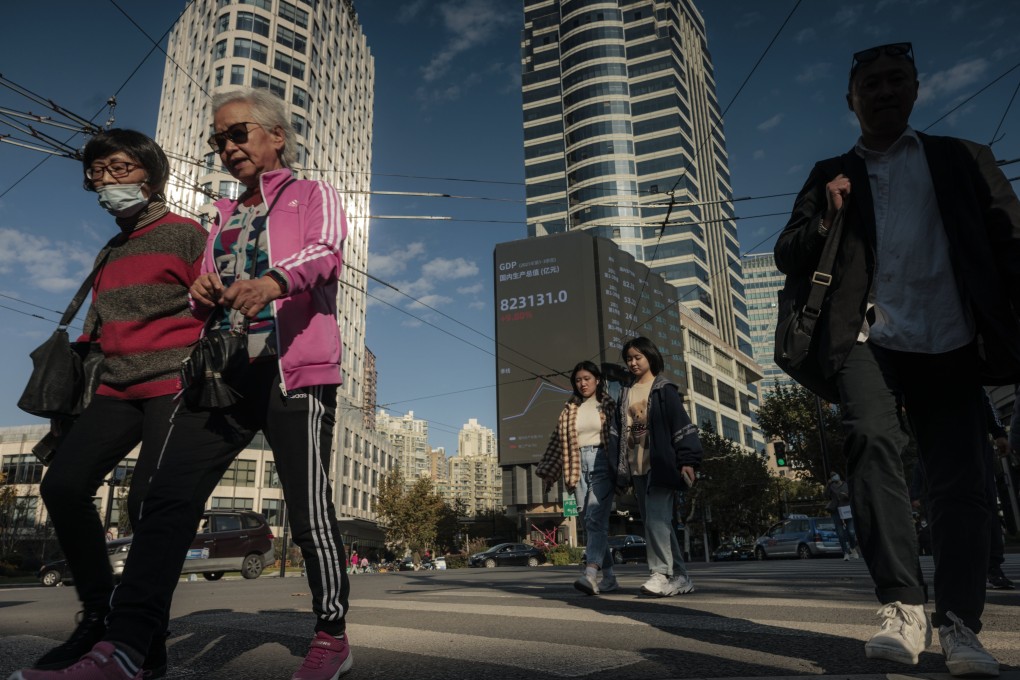 People walk on the street next to the large screen showing the stock exchange data in Shanghai in November 2021. Photo: EPA-EFE