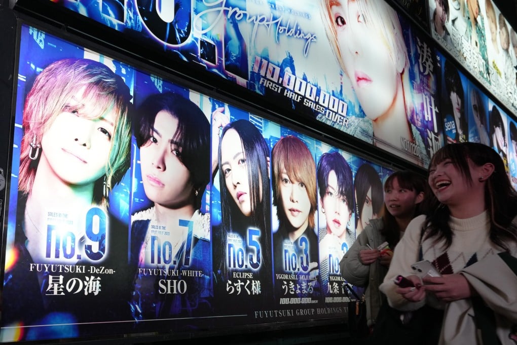 Women walk past an advertisement for a “host club” in the Shinjuku ward of Tokyo in December. Photo: EPA-EFE