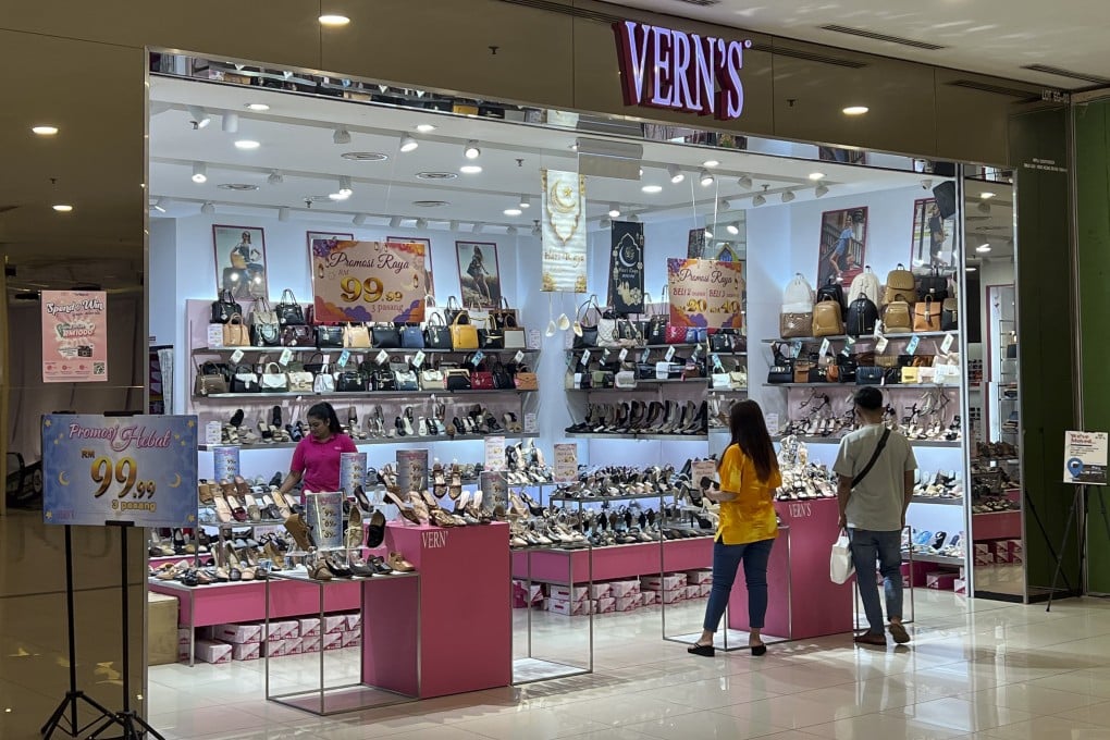 People shop at a Vern’s outlet at a shopping centre in Kuala Lumpur. Vern’s Holdings said the logo stamped on the soles of some high-heeled shoes depicted the silhouette of a stiletto heel with an ankle spiral wrap, not Arabic writing. Photo: AP