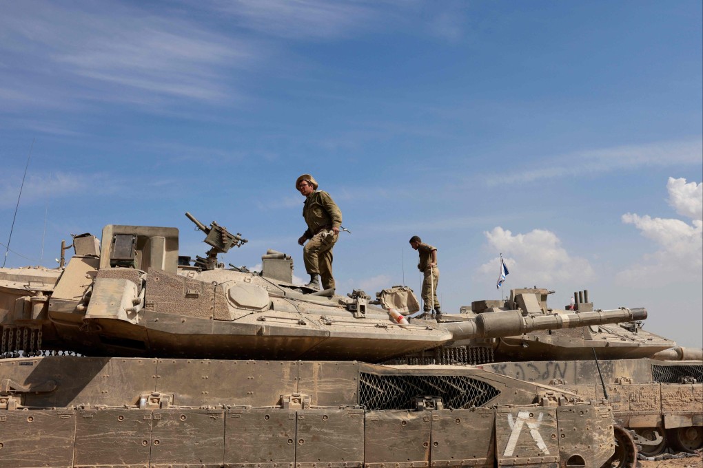 Israeli soldiers work on their tanks near the border with the Gaza Strip. Photo: AFP
