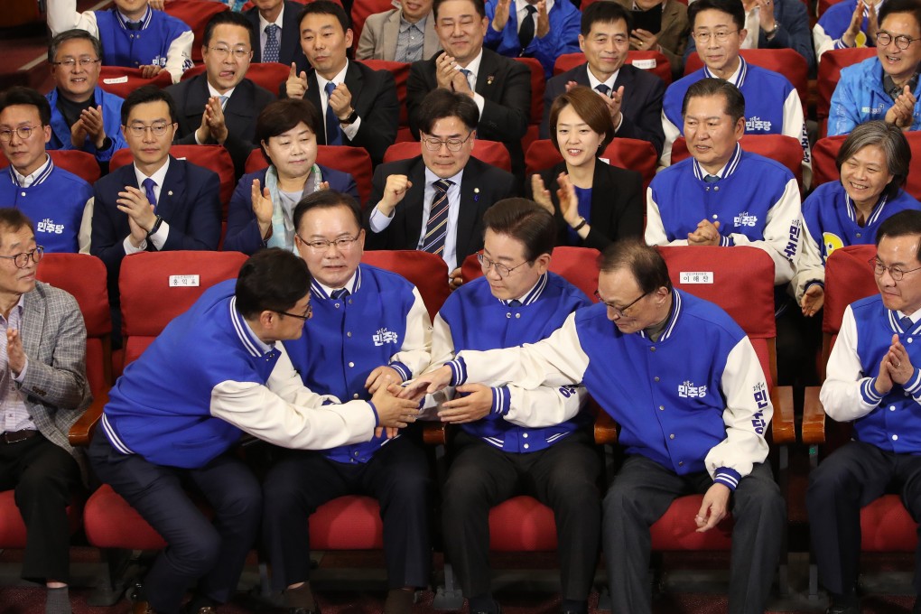 South Korea’s opposition Democratic Party leader Lee Jae-myung (front row, second from right) and candidates watch the broadcast of results of exit polls for the parliamentary election at the National Assembly in Seoul. Photo: EPA-EFE