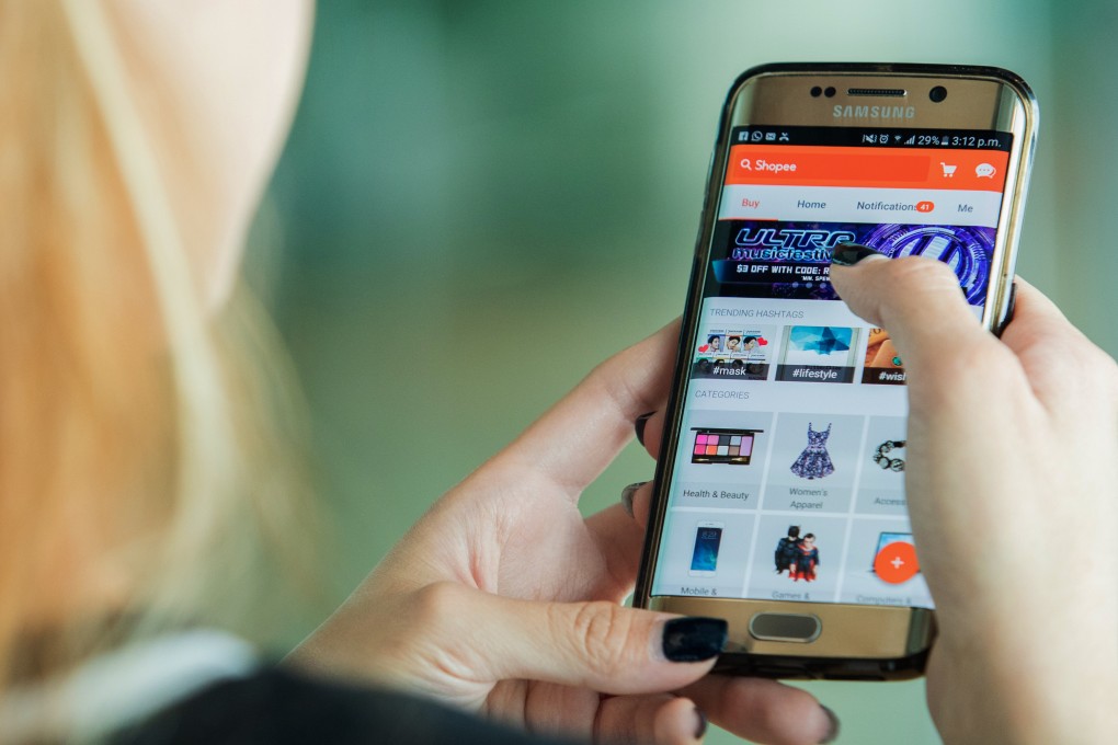 A woman uses the Shopee app on her smartphone at the company’s headquarters in Singapore. photo: Bloomberg