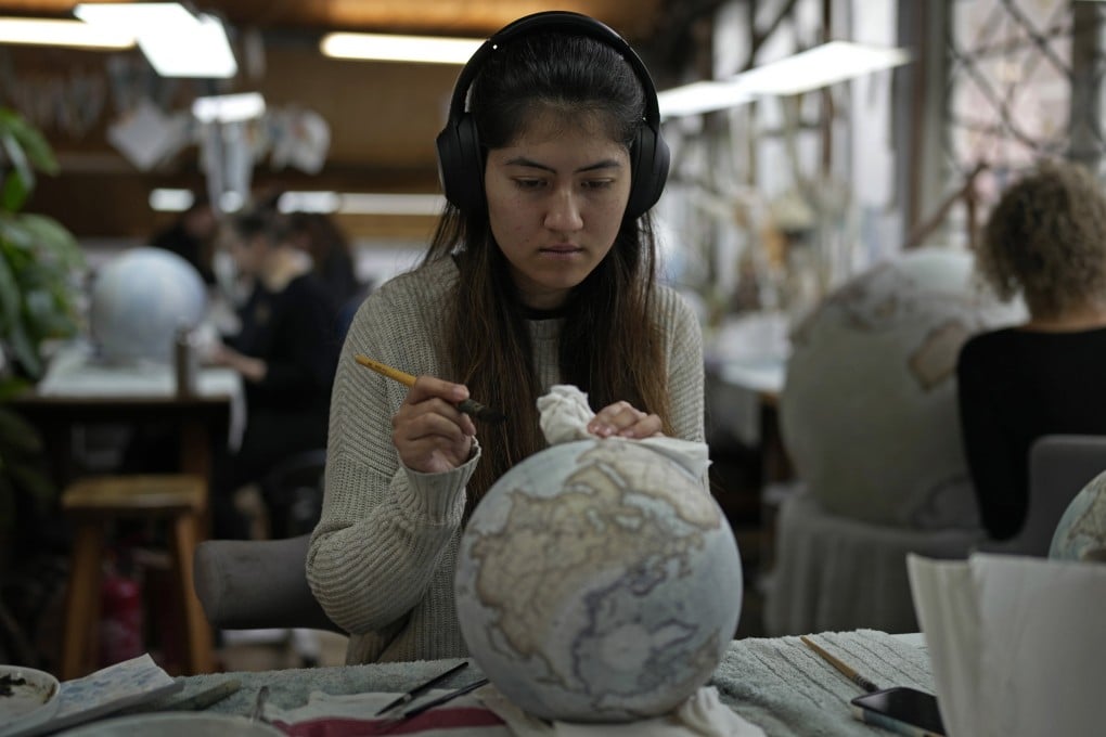 An artist paints a globe at the studio of Bellerby & Co Globemakers in London, England, on February 27, 2024. Many people still buy globes despite the invention of technologies like Google Earth and GPS. Photo: AP