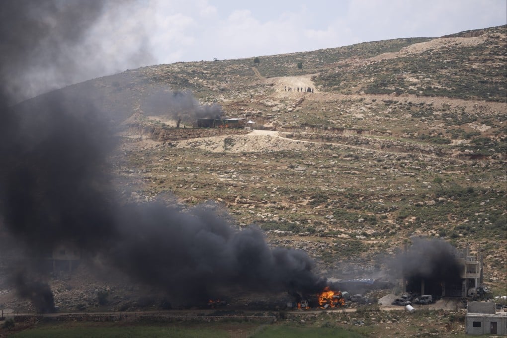 Israeli settlers gather near burning properties of Palestinians in the West Bank village of al-Mughayyir. The disappearance of 14-year-old Binyamin Achimair had sparked an attack by settlers. The youngster’s body was found on Saturday. Photo: AP