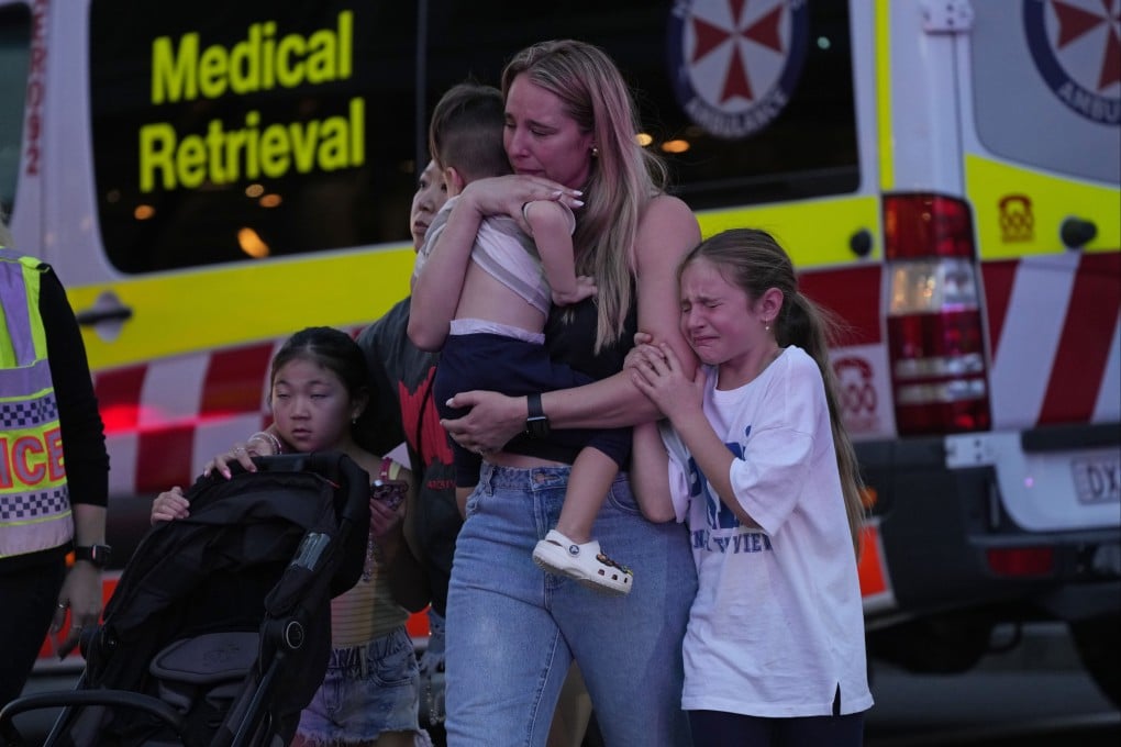 People are led out from a shopping centre in Sydney where multiple people were stabbed on Saturday. Photo: AP