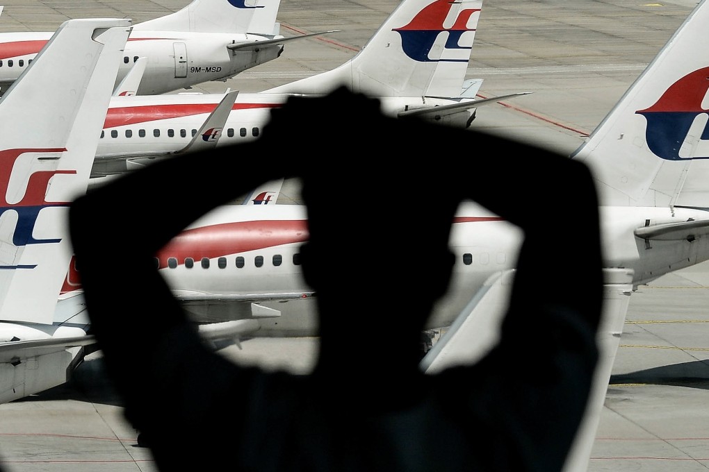 A man looks at aircraft on the tarmac at Kuala Lumpur International Airport. Police were investigating a rare shooting at the airport in connection to a domestic dispute. Photo: AFP