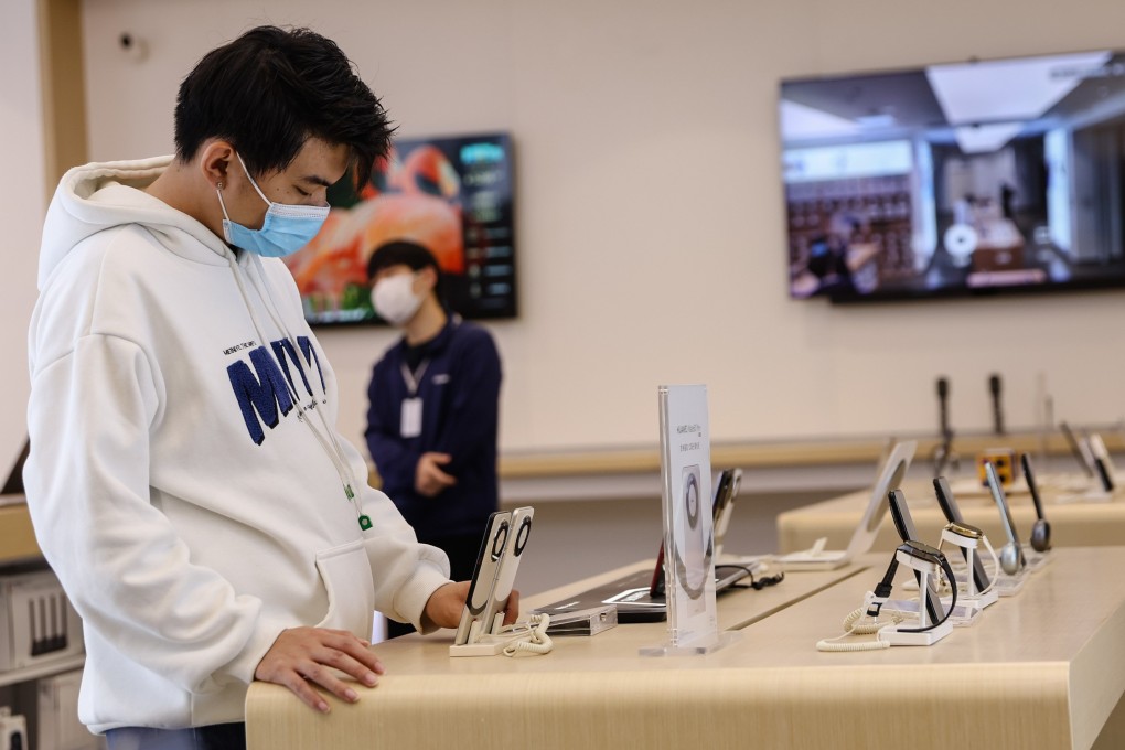 A man looks at smartphones in a store in Beijing on April 12. Consumer spending by China’s middle class is an important driver of the country’s economic growth, but government efforts to encourage greater consumption face headwinds. Photo: EPA-EFE