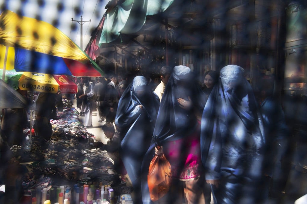 Seen through the eye grid of a burqa, women walk through a market in Kabul. The Taliban – who say they respect women’s rights in line with their interpretation of Islamic law and local customs – have closed girls’ high schools and placed travel restrictions on women without a male guardian and restricted access to parks and gyms. Photo: AP