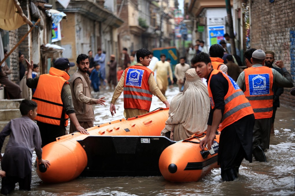 An area of Peshawar flooded after heavy rain is evacuated by volunteers with humanitarian NGO the Alkhidmat Foundation on Monday using a rubber raft. Photo: EPA-EFE