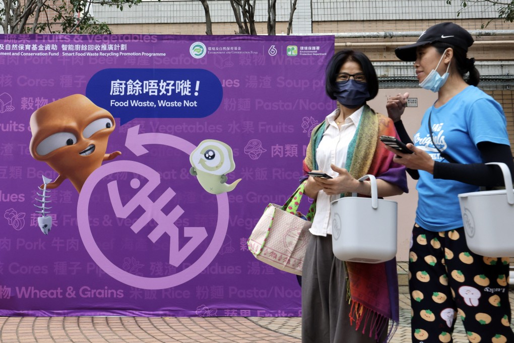 Residents carrying food waste disposal canisters walk past a poster promoting less wastage at Moon Lok Dai Ha in Tsuen Wan on April 9. Photo: Jelly Tse