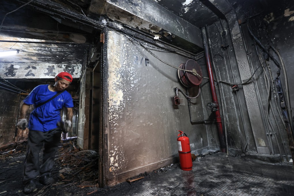 A worker carries out repairs at fire-damaged New Lucky House. Photo: Jelly Tse