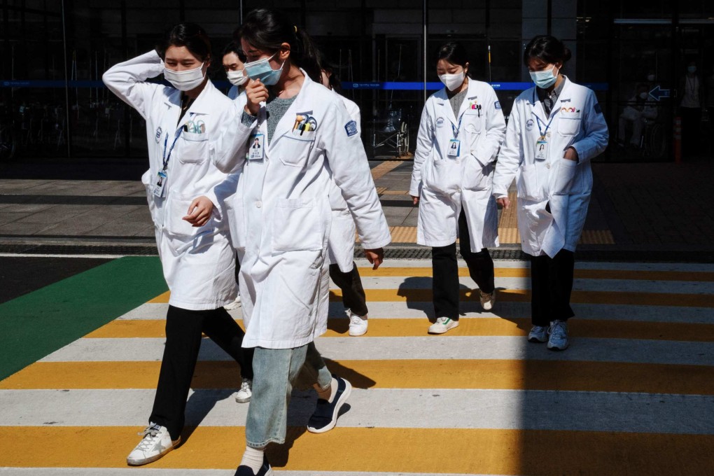 Medical workers walk crossing a street outside a hospital in Seoul. The South Korean government said it will adjust medical school quotas in a bid to end a walkout by junior doctors. Photo: AFP