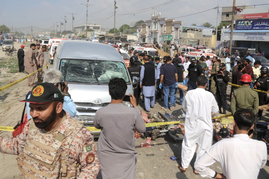Pakistani security officials and emergency workers gather at the scene of a suicide bomb attack in Karachi on Thursday. Photo: EPA-EFE