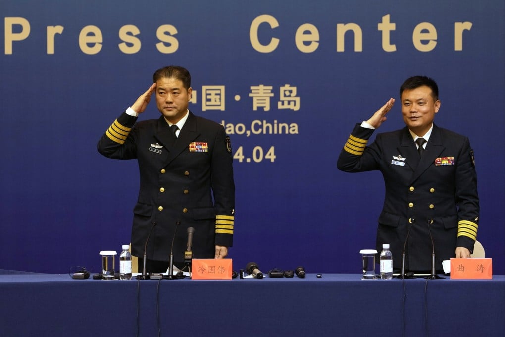 Senior Colonel Qu Tao (right) and a PLA Navy spokesman salute at the end of a press conference on Saturday in Qingdao, in eastern China’s Shandong province. Photo: AP