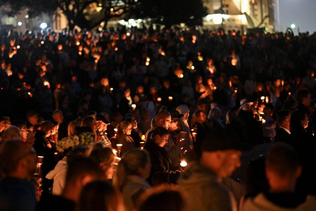 People hold candles during a candlelight vigil, recognising the victims of a fatal stabbing attack at Bondi Junction Westfield shopping centre, in Sydney, Australia, on Sunday. Photo: Reuters