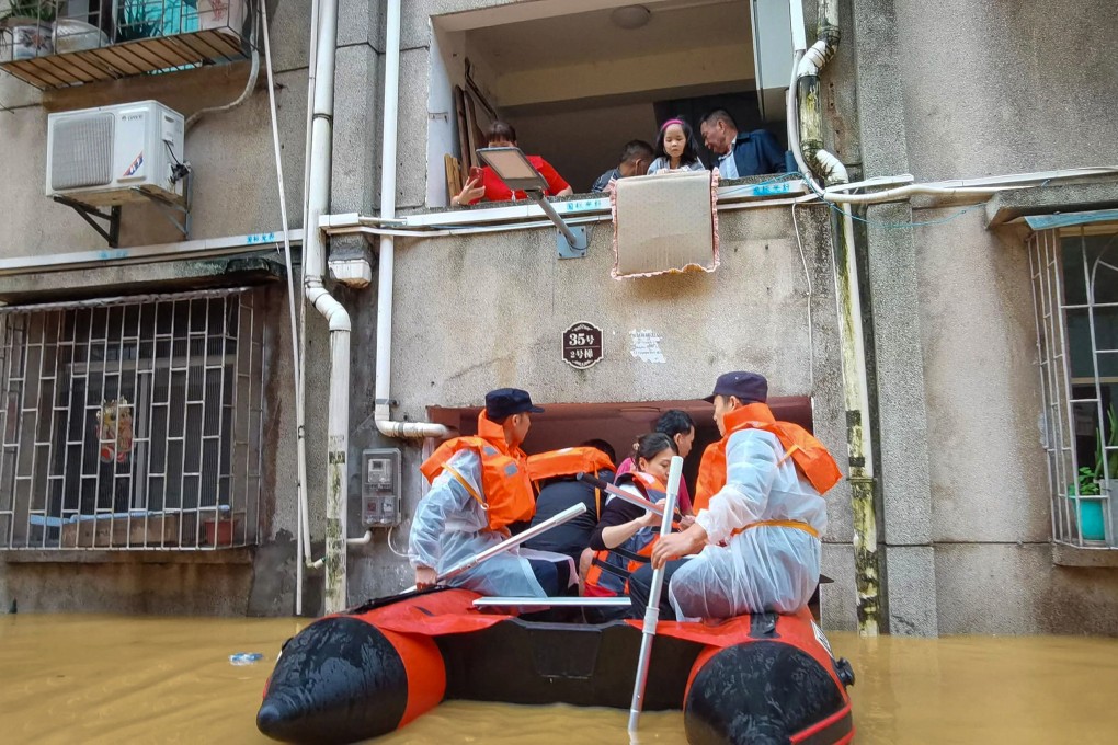 Shaoguan emergency workers help stranded residents evacuate their home on Saturday. Photo: Xinhua