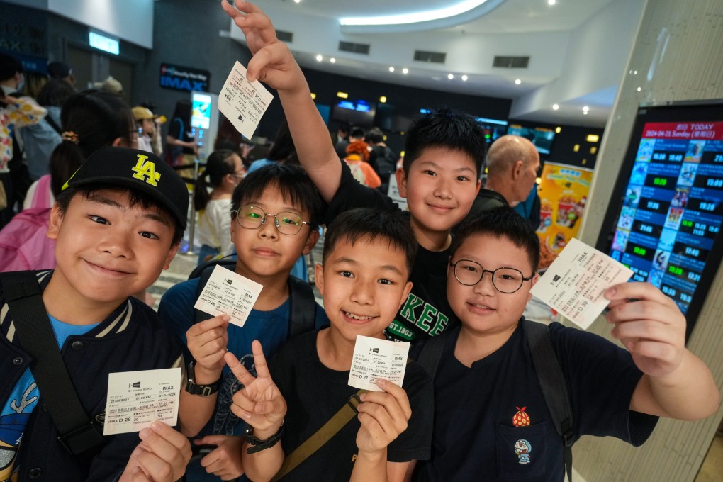 Happy young film fans show off their cut-price cinema tickets on Cinema Day. Photo: Sam Tsang