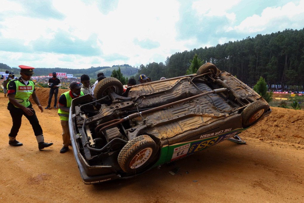 Track attendants inspect a car that came off a racetrack in Diyatalawa, Sri Lanka, on Sunday. Thousands of spectators looked on as the mishap took place. Photo: AFP