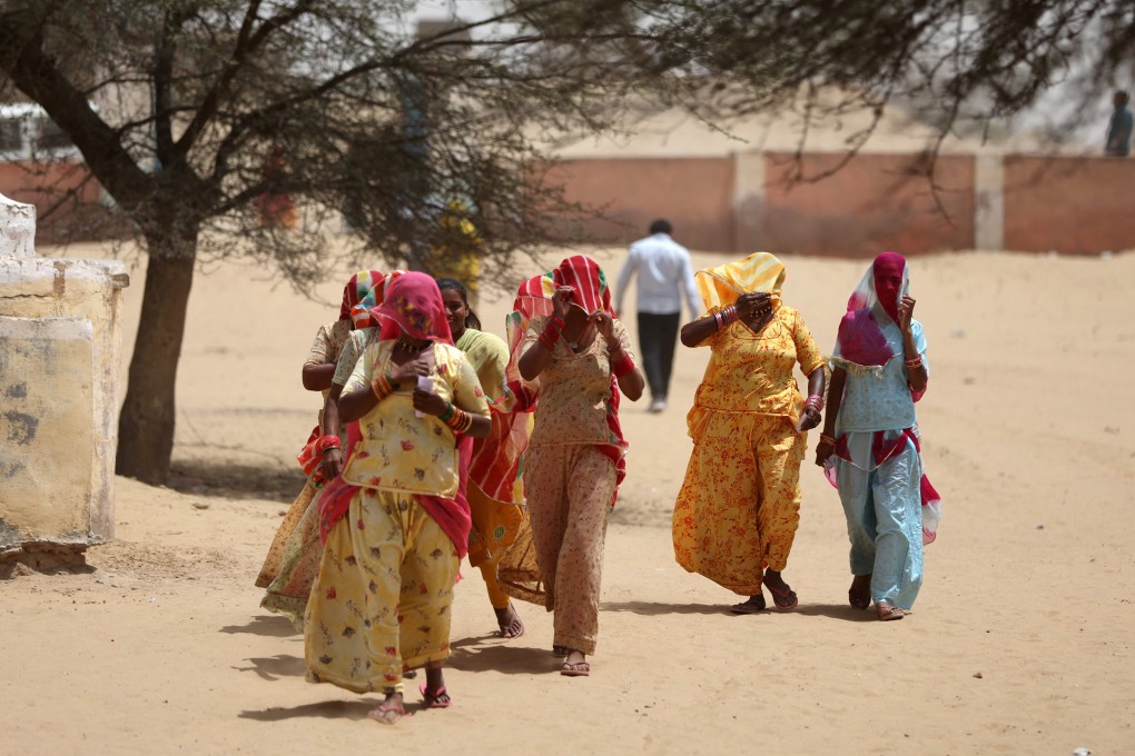 Women cover their faces to protect themselves from the heat as they arrive at a polling station in Rajasthan on Friday. Photo: Reuters