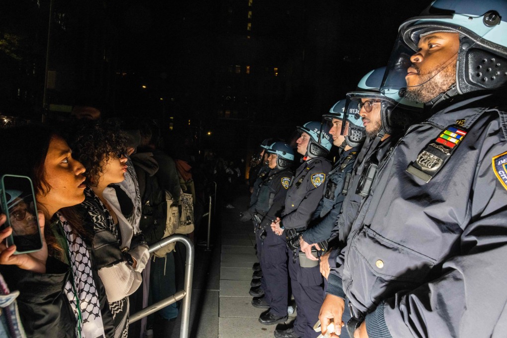 Pro-Palestinian students and activists face police officers on the New York University campus on Monday. Photo: AFP